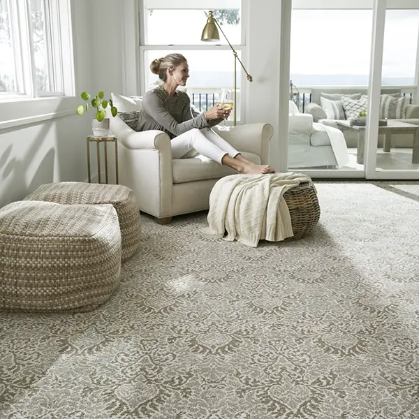 Woman sitting in a newly carpeted well lit room | DeGraaf Interiors